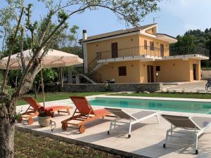 a villa with a swimming pool in front of a house at Villa Santa Lucia in Noto