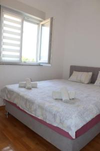 a large bed in a room with two windows at Apartman Ena in Bileća