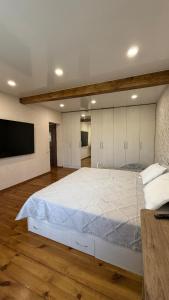 ein Schlafzimmer mit großem Bett und Flachbildfernseher in der Unterkunft Wood house ukg in Öskemen