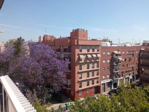 a tall building with purple trees in front of it at ELIO Murcia El Carmen in Murcia