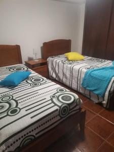 two beds sitting next to each other in a room at Casa mãe in Lajes do Pico