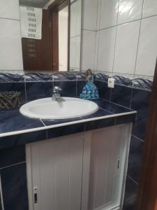 a bathroom with a white sink and a mirror at Casa mãe in Lajes do Pico +11 photos