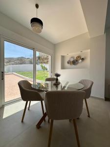 a dining room with a glass table and chairs at Villa Yimaré mit privatem Pool und Meerblick in Gázion