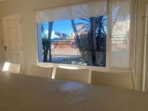 a room with a table and chairs and a large window at Jardín del Mar in Playa Unión +18 photos