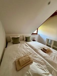 un grande letto bianco con un asciugamano sopra di Studio Lilly a Bohinj