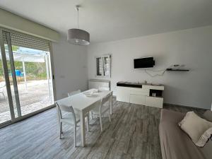 a white living room with a table and a couch at Tenuta Sillo - ground floor in Uggiano Montefusco