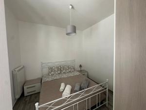 a small bedroom with a bed with a white headboard at Tenuta Sillo - ground floor in Uggiano Montefusco