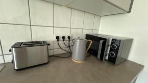 un bancone cucina con forno a microonde e macchinetta del caffè di Nisas Ferienwohnung a Bad Säckingen 1 altra foto