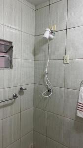eine Dusche mit Duschkopf in einem Badezimmer in der Unterkunft Quarto Solteiro Bougainville 2 in Areia