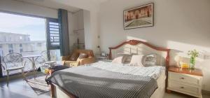 a bedroom with a large bed and a balcony at The Green Room in Nanning +11 photos