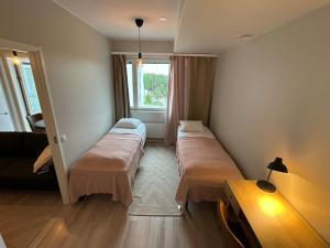 a room with two beds and a window at Apartment in Kuopio's Archipelago City in Kuopio