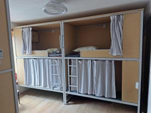 深圳Kuaike Xingjiduo Apartment的客房设有带窗帘的两张双层床。 更多1张照片