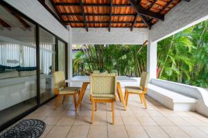 a patio with a table and chairs on a balcony at Villa Serenidad Costera in Sardinal