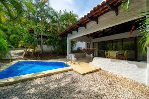 a swimming pool in the backyard of a house at Villa Serenidad Costera in Sardinal