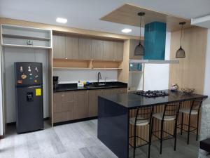 a kitchen with a refrigerator and a black counter top at Sony Cel's Little Corner in Azogues