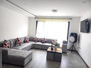 a living room with a couch and a television at Sony Cel's Little Corner in Azogues