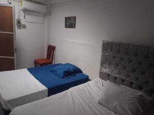 a hotel room with two beds and a cat sleeping on the bed at Posada María Elvia Villahermosa in Villahermosa