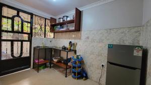 a kitchen with a counter and a refrigerator in it at Milele Homestay in Boma la Ngombe