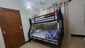 a room with two bunk beds and a door at Milele Homestay in Boma la Ngombe