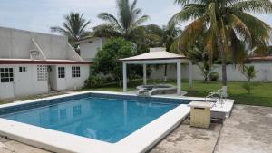 a swimming pool with a gazebo next to a house at Casa, alberca privada y jardín in Tecolutla +4 photos