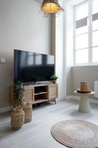 a living room with a flat screen tv on a entertainment center at Suite sensuelle et balnéothérapie in Nemours