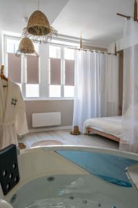a bathroom with a tub and a bedroom with a bed at Suite sensuelle et balnéothérapie in Nemours