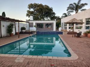 a swimming pool in front of a house at Cottage in Kloofendal in Roodepoort