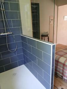a blue tiled wall in a bathroom with a mirror at cosy logis et son écrin de verdure in Cordes-sur-Ciel