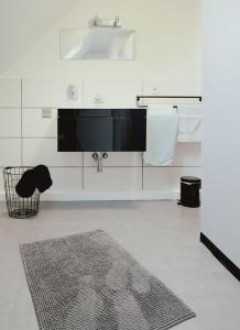 a white bathroom with a sink and a rug at Jül Boardinghouse in Jülich +46 photos
