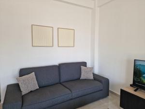 a living room with a couch and a tv at Kafkalia Sea Breeze in Larnaka