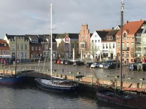 a group of boats docked in a harbor with buildings at Holiday home in Husum with swimming pool in Husum