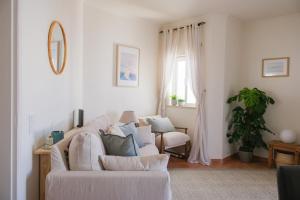 a living room with a white couch and a window at Charming Lagos Stay - Walk to Beach & Historic Centre in Lagos