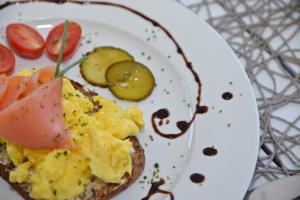 a plate of food with eggs and tomatoes on it at Franskraal Bed and Breakfast Pty Ltd in Franskraalstrand +19 photos