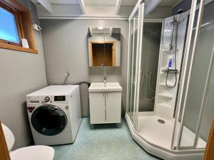 a bathroom with a washing machine and a shower at Rolig sted med fantastisk utsikt in Longyearbyen