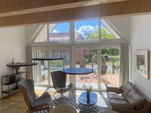 a living room with a table and chairs and a large window at Holiday home in Zingst with swimming pool in Zingst