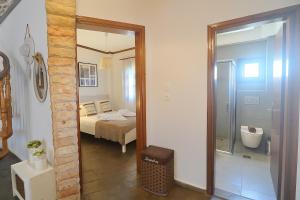 VergiaPalm Nest Villa with private pool in Chalkidiki的一间带床的卧室和一间带镜子的浴室