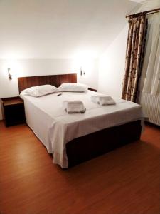 a bedroom with a large bed with white sheets at Casa Catalyna in Predeluţ