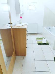 a bathroom with a white tiled floor and a sink at Casa Catalyna in Predeluţ +24 photos