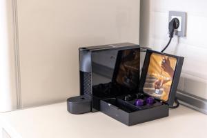 a tv with a box on a table with purple candles at Amalia Deluxe Villas in Nea Vrasna