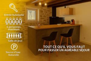 a kitchen with a counter with two stools next to it at Nature et Sérénité in Fontpédrouse