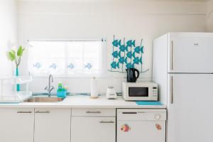 a white kitchen with a white refrigerator and a microwave at Villas on Great Bay VILLA FOXIE in Philipsburg