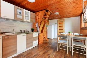 a kitchen with white cabinets and a wooden ceiling at Erdei Kabin Nagymaros in Nagymaros