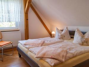 a bedroom with a bed with white sheets and pillows at Holiday apartment in Tharandt with Wi-Fi in Tharandt