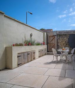 a patio with a table and chairs next to a building at Margate Old Town & Beach, Stylish 3 bed House with Garden in Margate