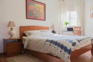 a bedroom with a bed with a blue and white blanket at Charming Lagos Stay - Walk to Beach & Historic Centre in Lagos