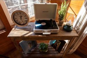ein Tisch mit einem Laptop und einer Uhr darauf in der Unterkunft Bear's Den Couples Cabin Hot Tub Pets in Sautee Nacoochee