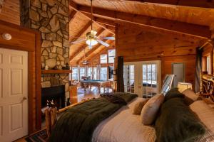 ein Schlafzimmer mit einem großen Bett und einer Steinwand in der Unterkunft Bear's Den Couples Cabin Hot Tub Pets in Sautee Nacoochee