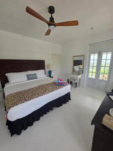 una camera con un grande letto e un ventilatore a soffitto di Large Beautiful Villa with Ocean Views and private pool - 3 Bedroom Listing a Cap Estate Altre 37 foto