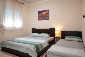 ein Schlafzimmer mit zwei Betten und einem Fenster in der Unterkunft MareAntoanetta in Nea Kallikratia