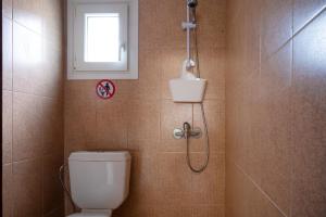 eine Dusche im Bad mit WC und Fenster in der Unterkunft MareAntoanetta in Nea Kallikratia + 19 Fotos
